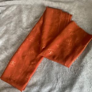 Orange/brown chiffon scarf includes prints of “Calvin klein”.